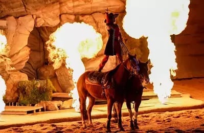 rider on two horses with fire at Stampede