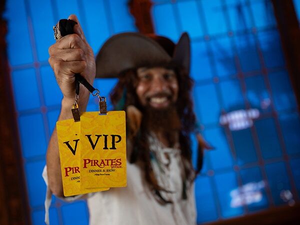Pirate holding out the VIP passes at Pirates Voyage