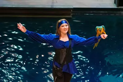 Pirates Voyage performer holding a tropical bird