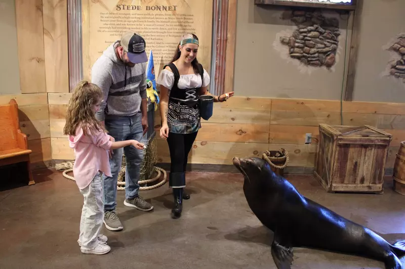 family and trainer with sea lion