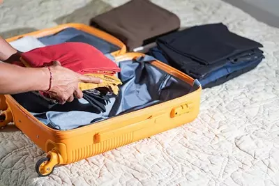 person packing suitcase